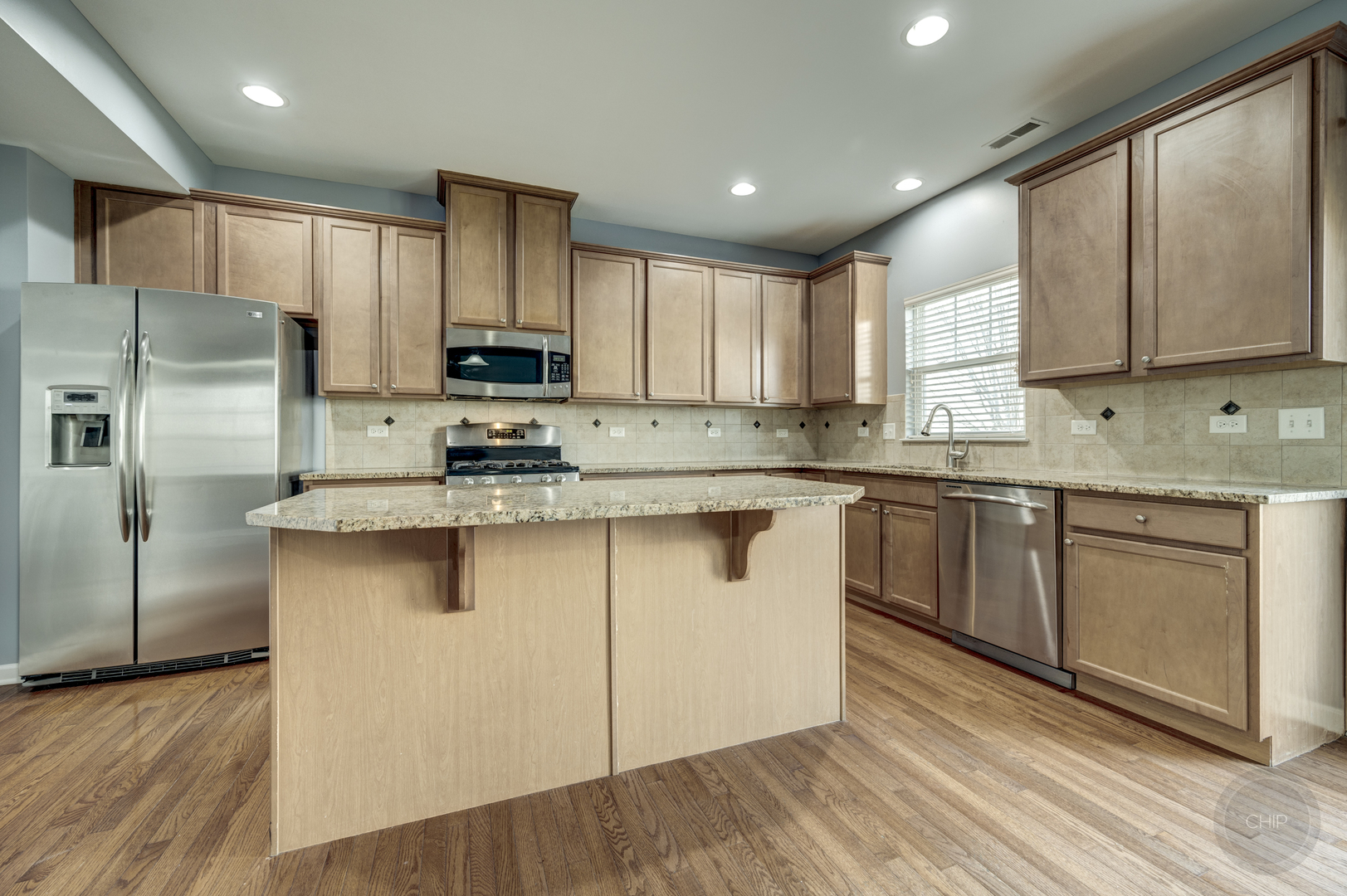 331 North Commerce Street Aurora, IL 60504 - Photo 17 of 41 a kitchen with stainless steel appliances granite countertop a stove a sink dishwasher a refrigerator and a microwave oven on the wooden floor