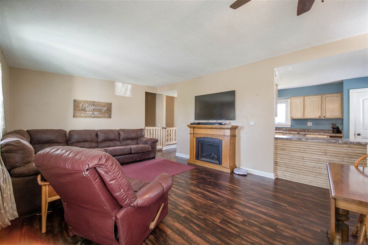 6775 South Sarah Avenue Rochelle, IL 61068 - Photo 11 of 26 a living room with furniture a fireplace and a flat screen tv