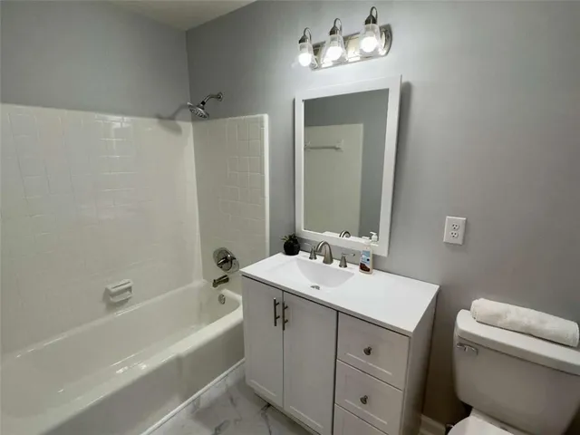 a bathroom with a tub a sink and a mirror