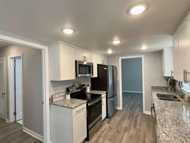 a kitchen with stainless steel appliances granite countertop a stove a sink and a refrigerator