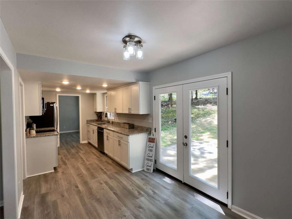 6 Westlyn Drive Rome, GA 30165 - Photo 8 of 25 a kitchen with stainless steel appliances granite countertop a refrigerator oven a sink dishwasher and white cabinets with wooden floor