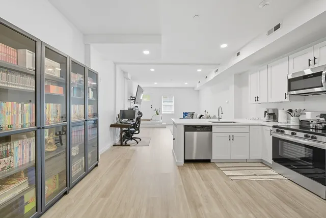 a kitchen with cabinets and wooden floor