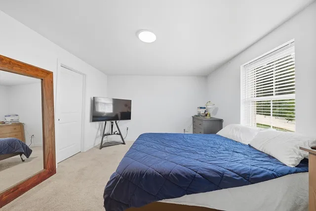 a bedroom with a bed and a potted plant