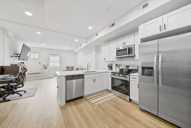 a kitchen with a sink stainless steel appliances and cabinets
