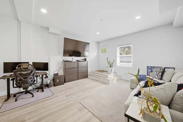 a living room with furniture a flat screen tv and a window