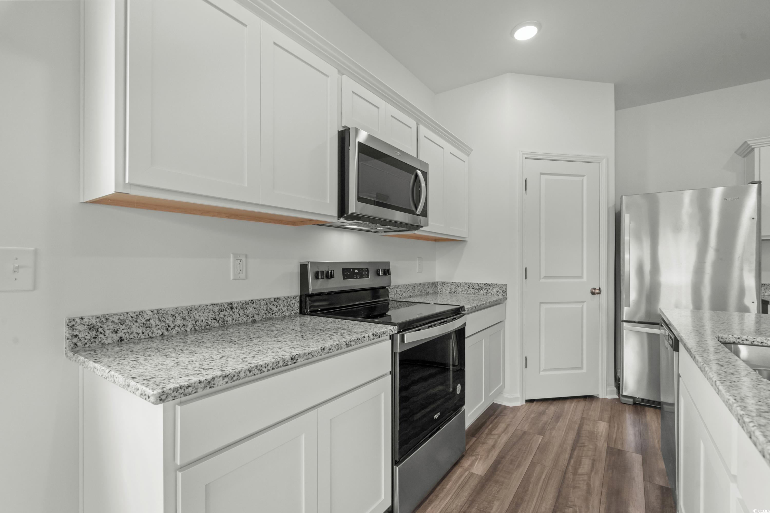 435 Castillo Drive Longs, SC 29568 - Photo 7 of 27 Kitchen with stainless steel appliances, light stone counters, dark wood finished floors, and white cabinetry