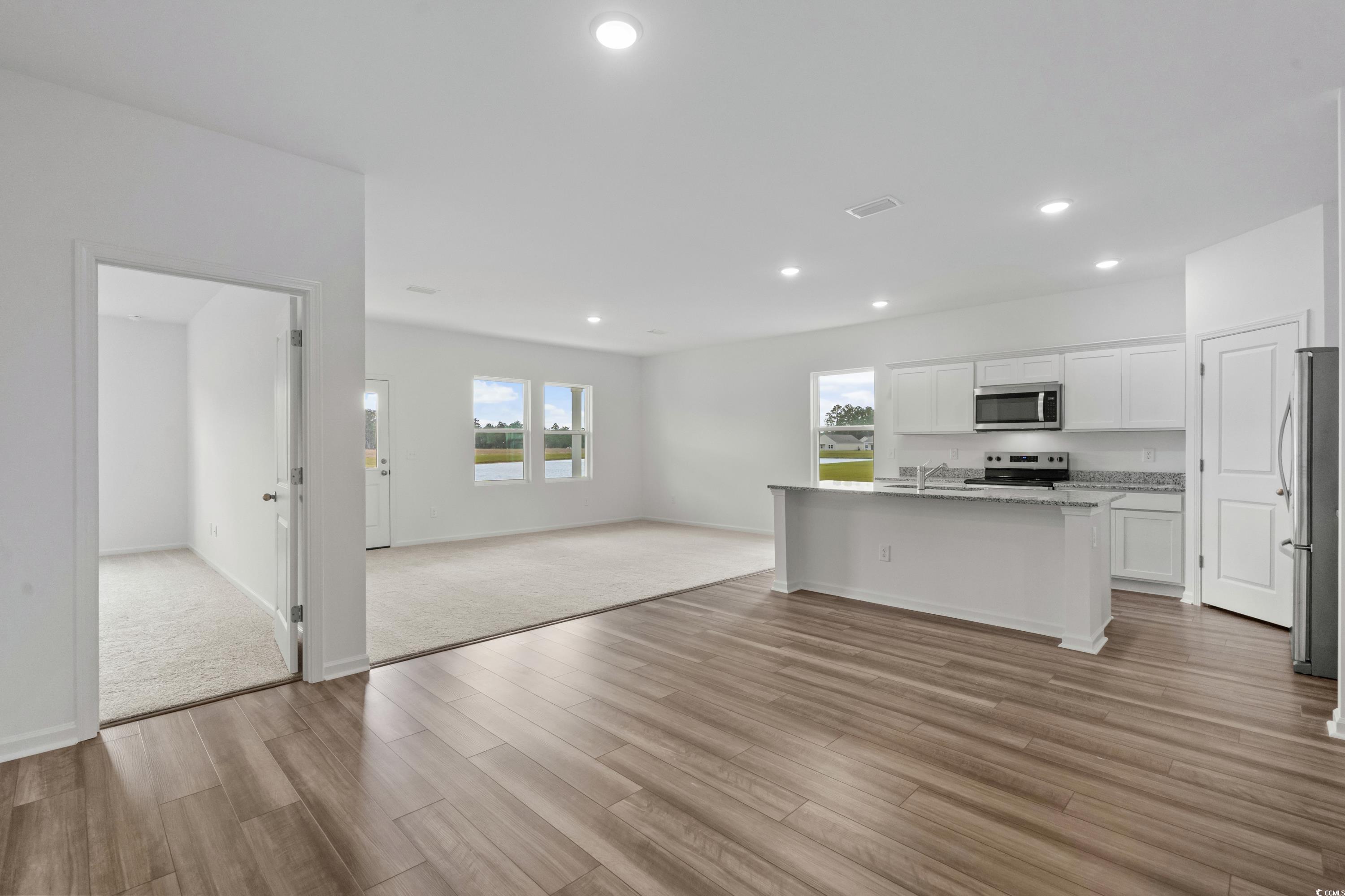 435 Castillo Drive Longs, SC 29568 - Photo 27 of 27 Kitchen with open floor plan, white cabinetry, a kitchen island with sink, appliances with stainless steel finishes, and light wood-type flooring