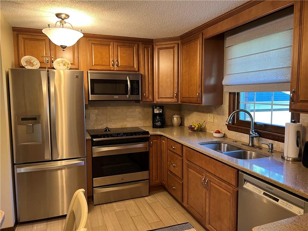 200 Courtland Road Indiana, PA 15701 - Photo 5 of 42 a kitchen with stainless steel appliances granite countertop a refrigerator a stove a sink and dishwasher with wooden floor