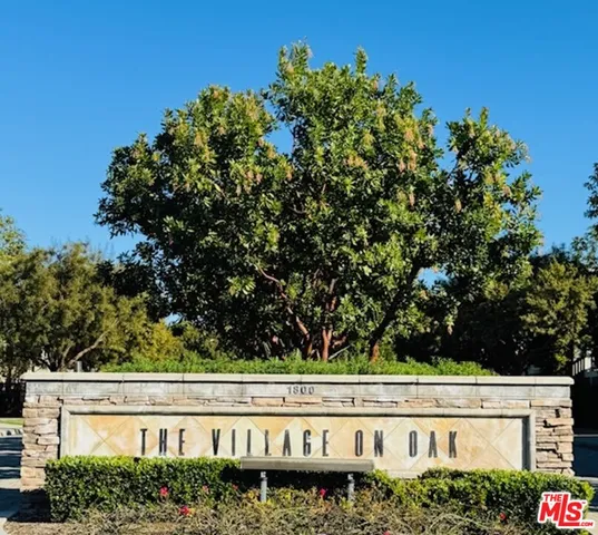 a view of a street sign under a large tree