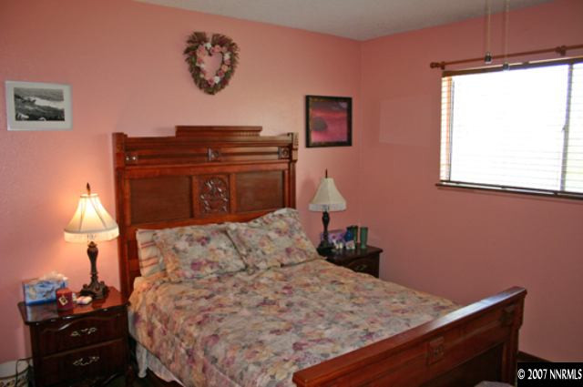 1285 Beldon Way Reno, NV 89503 - Photo 6 of 8 a bed sitting in a bedroom next to a lamp