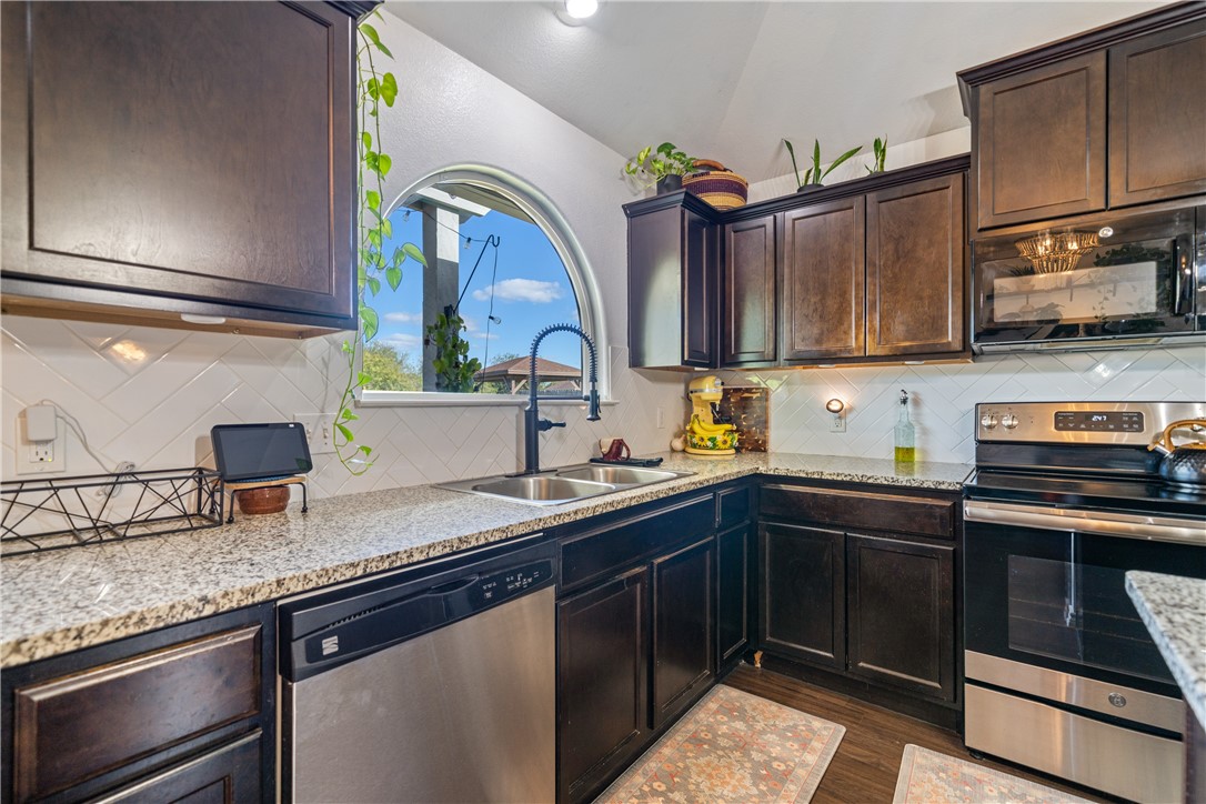 7442 Russ Lane Corpus Christi, TX 78414 - Photo 11 of 29 a kitchen with granite countertop a sink stainless steel appliances and cabinets