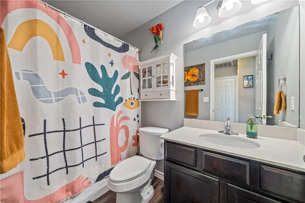 a bedroom with a bed and a flat tv screen on dresser