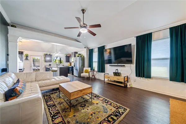 a kitchen with stainless steel appliances granite countertop a refrigerator a stove top oven a dining table and chairs with wooden floor