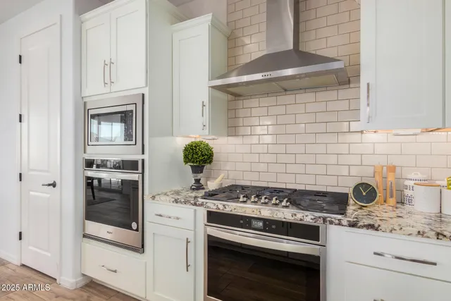 a large kitchen with kitchen island a table and chairs in it