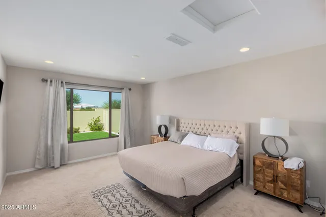 a bedroom with a bed and a lamp on dresser