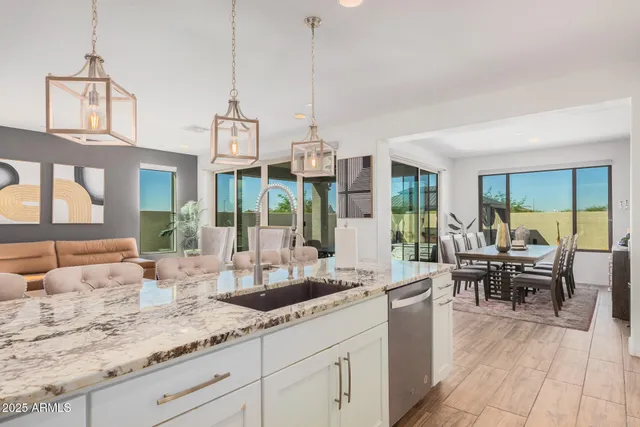 a kitchen with stainless steel appliances kitchen island granite countertop a sink stove and refrigerator