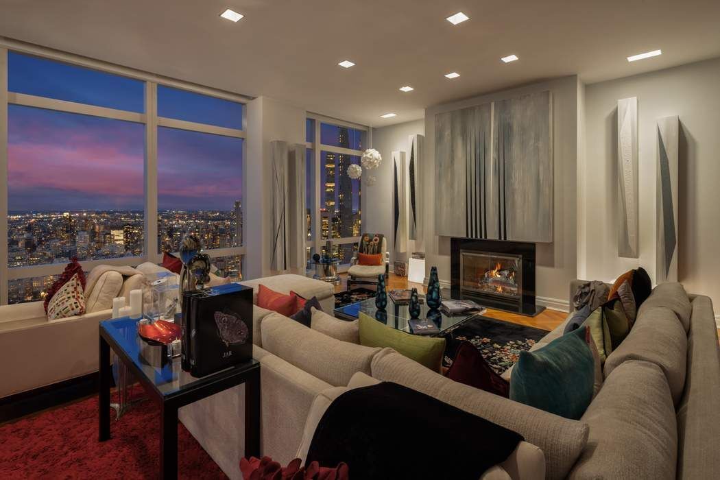 80 Columbus Circle, Unit 80 Manhattan, NY 10019 - Photo 18 of 30 a living room with furniture a fireplace and a floor to ceiling window