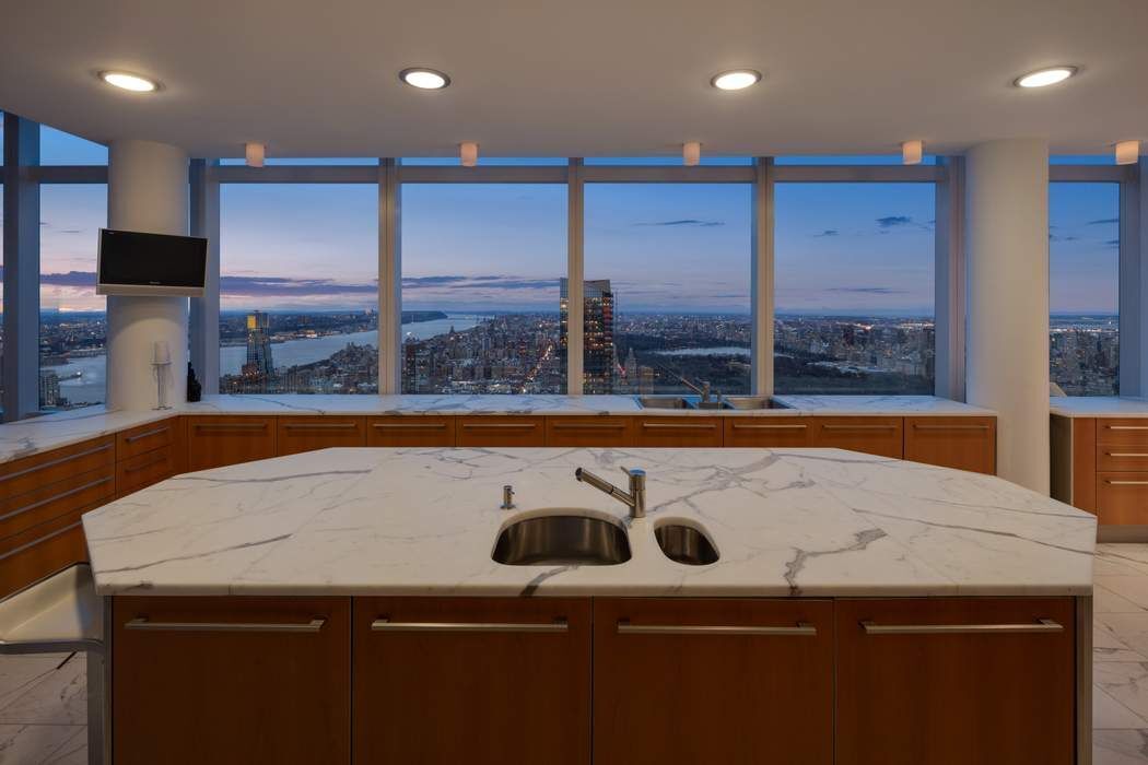 80 Columbus Circle, Unit 80 Manhattan, NY 10019 - Photo 20 of 30 a view of a kitchen island a sink a counter top and stainless steel appliances