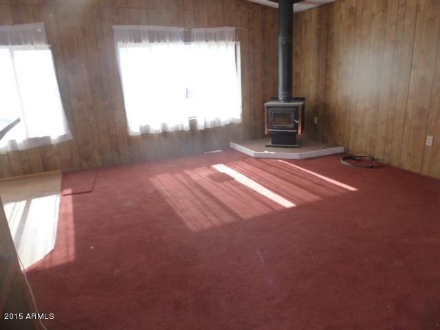 1395 South Yellow Brick Road Chino Valley, AZ 86323 - Photo 5 of 13 an empty room with a fireplace and windows