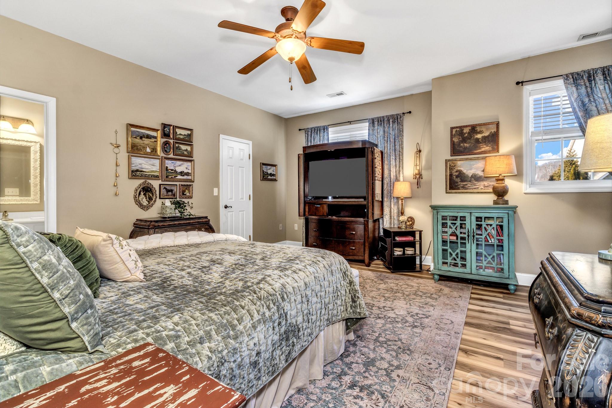 25 Union Chapel Road Weaverville, NC 28787 - Photo 23 of 43 a bedroom with a bed a dresser and a chandelier
