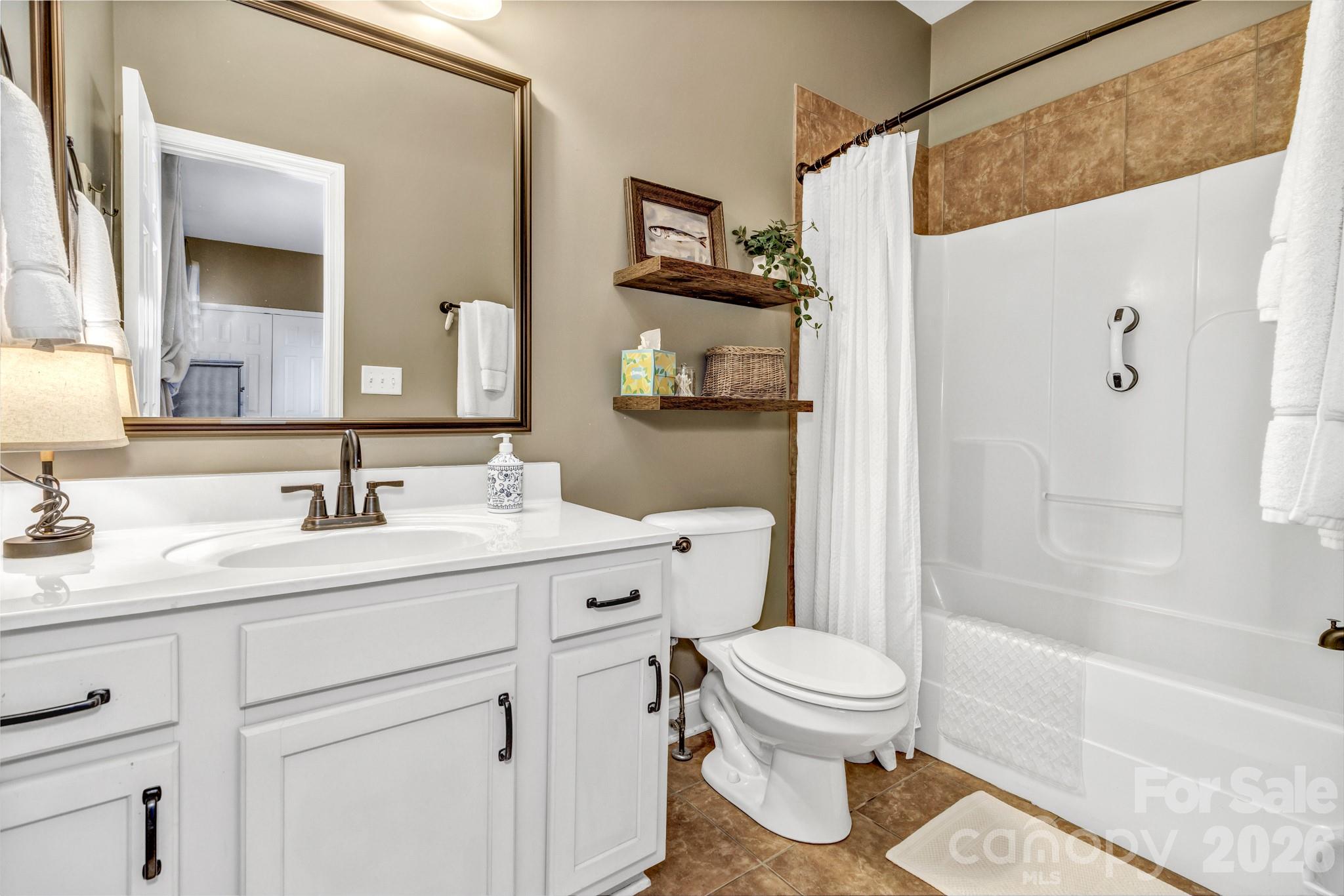 25 Union Chapel Road Weaverville, NC 28787 - Photo 32 of 43 a bathroom with a granite countertop sink toilet a mirror a vanity and shower