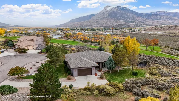 an aerial view of a house with a garden and lake view