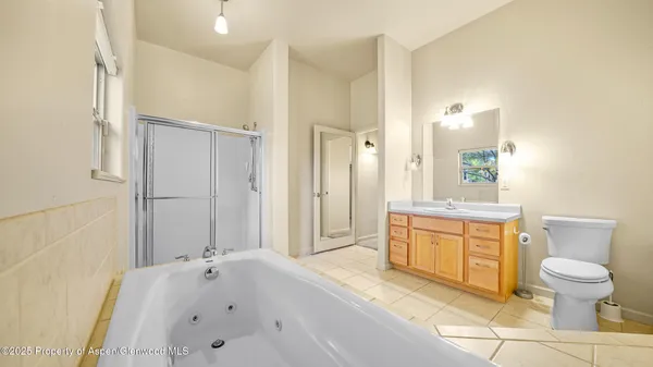 a spacious bathroom with a granite countertop sink toilet and shower