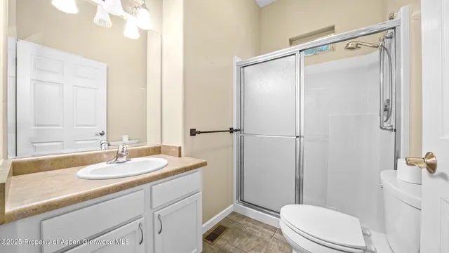 a bathroom with a sink a toilet a mirror and shower