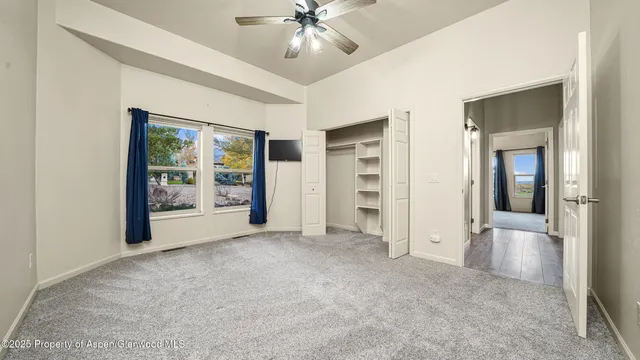 an empty room with closet and windows