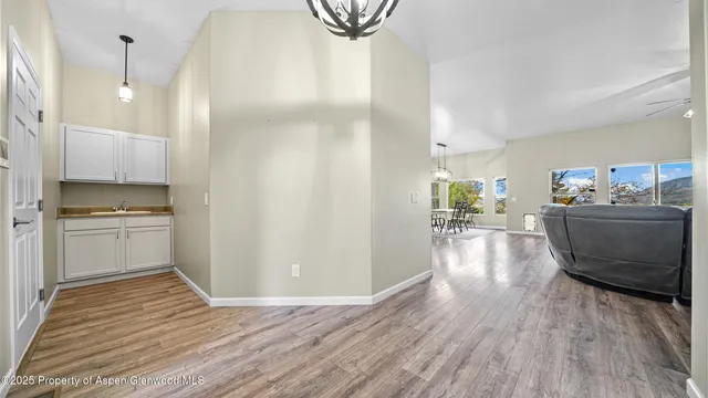 a view of a kitchen with kitchen island a sink wooden floor and stainless steel appliances