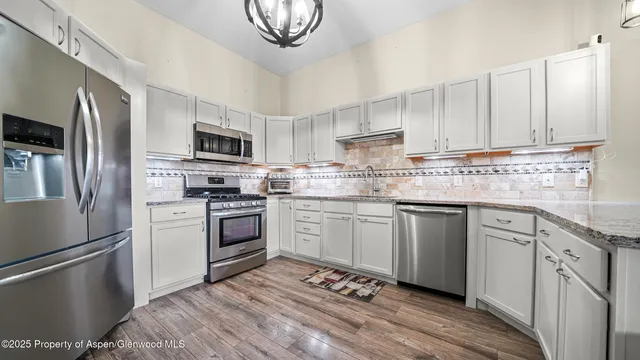 a kitchen with cabinets stainless steel appliances and a counter space