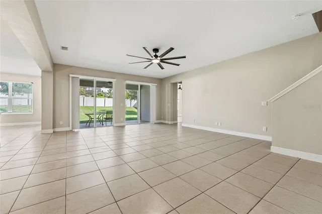 an empty room with windows and chandelier