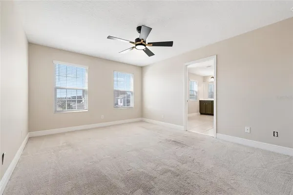 an empty room with windows and fan