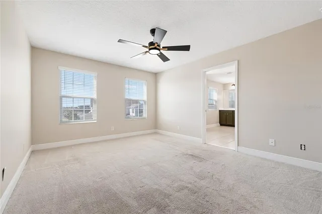 an empty room with windows and fan