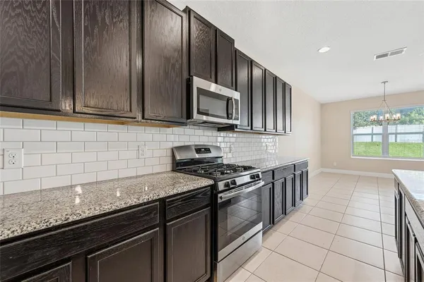 a kitchen with granite countertop a stove sink and cabinets