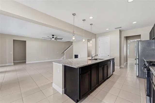 a kitchen with a sink a counter top space stainless steel appliances and cabinets