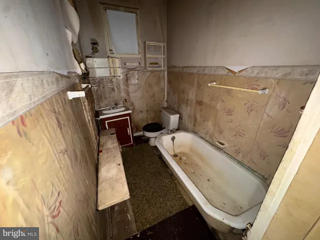 a bathroom with a tub sink and toilet