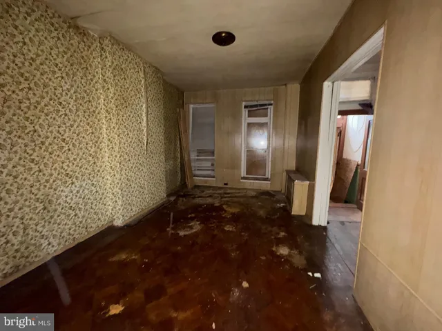 a bed sitting in a bedroom next to a window and a chandelier