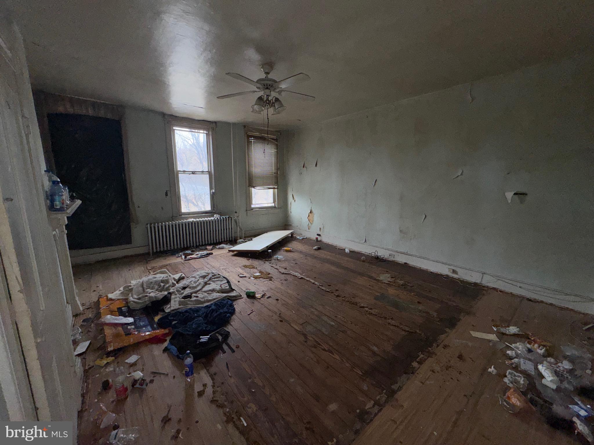 105 North Fulton Avenue Baltimore, MD 21223 - Photo 18 of 38 a bed sitting in a bedroom next to a window and a chandelier