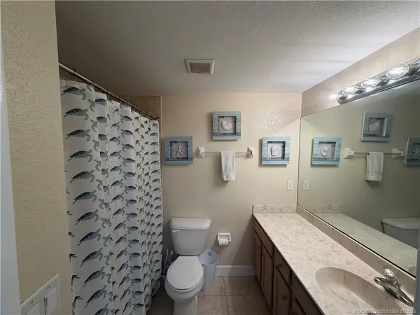 a spacious bathroom with a granite countertop toilet a sink and a mirror