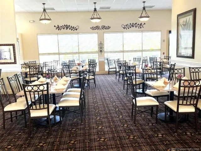 a dining room with furniture a chandelier and wooden floor