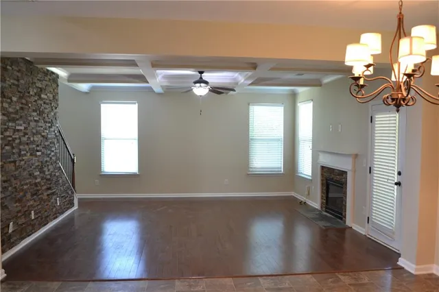a view of an empty room with wooden floor and a floor to ceiling window