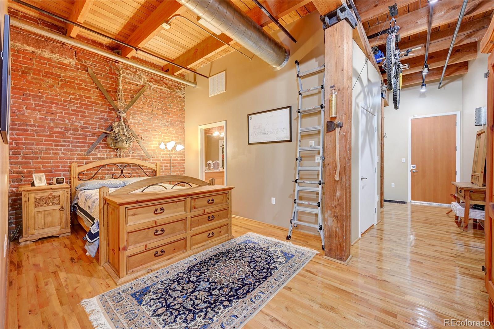 2960 Inca Street, Unit 313 Denver, CO 80202 - Photo 14 of 27 a room with lots of wooden furniture and a rug