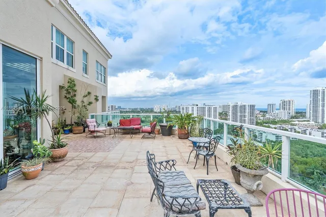 a view of a patio with a dining table and chairs with wooden fence