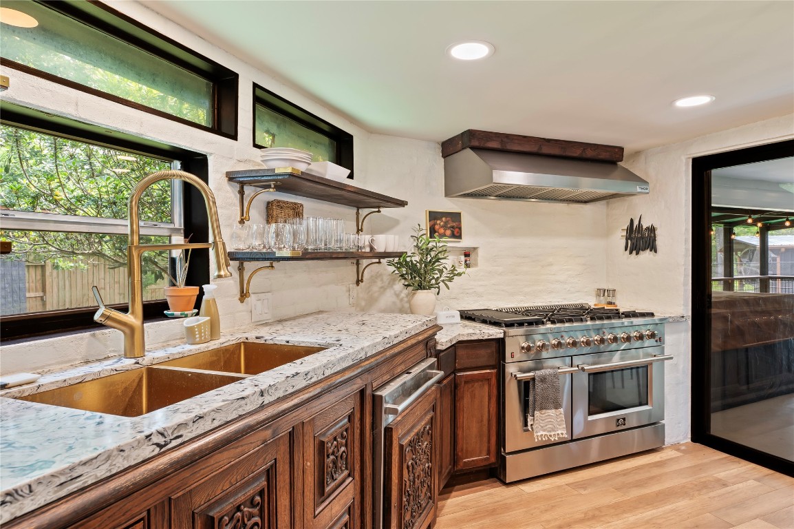1908 Deats Road Dickinson, TX 77539 - Photo 11 of 41 Granite counter tops, double sink with brass fixtures, and views looking out into the wooded property.