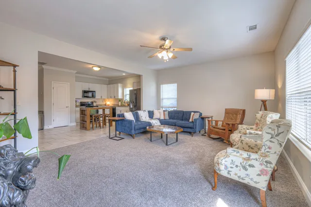a living room with furniture and a dining table with chairs