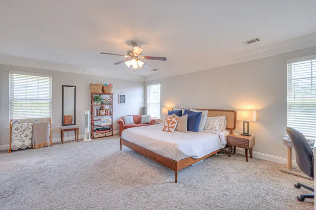 a spacious bedroom with a bed and a chandelier