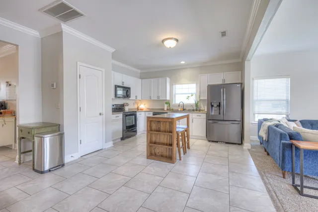 a kitchen with white cabinets and stainless steel appliances