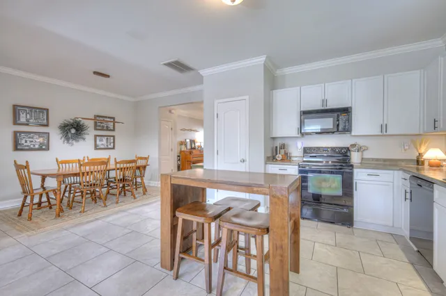 a kitchen with stainless steel appliances granite countertop a table and chairs in it