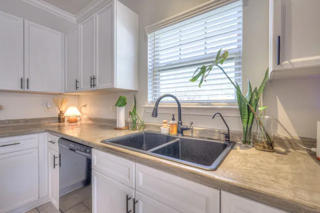 a kitchen with stainless steel appliances sink a window and cabinets